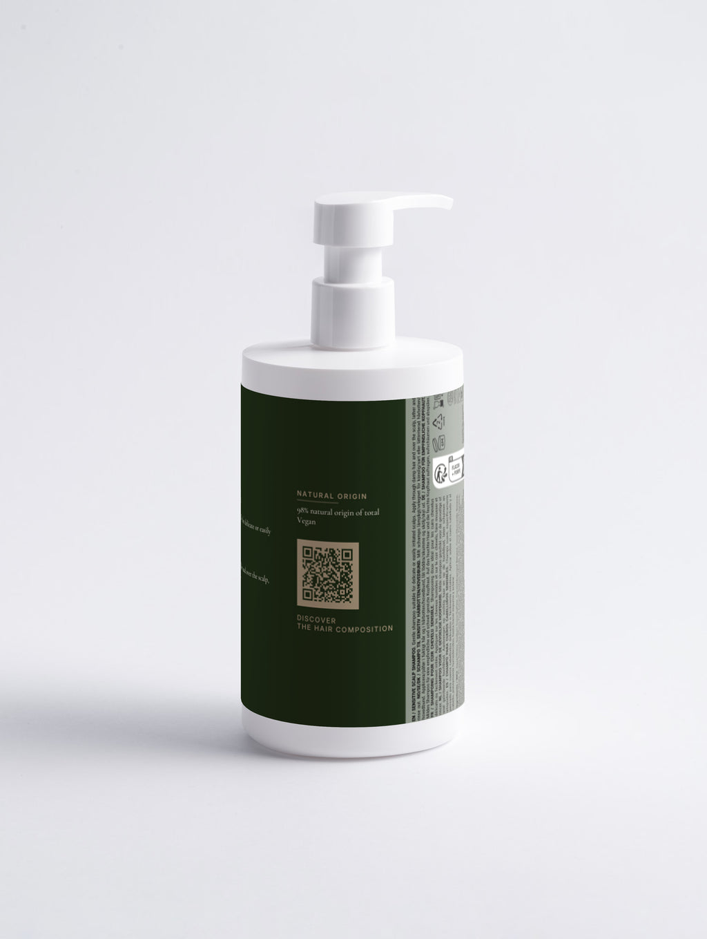 The same bottle rotated to show the natural origin panel with the Hair Composition QR code and the printed multilingual regulatory panel.