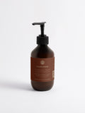 Silk Skin Hand Cream, Spices & Sandalwood — 270 ml amber pump bottle with the SEV Apothecary label of The Body Composition, on a plain studio background.