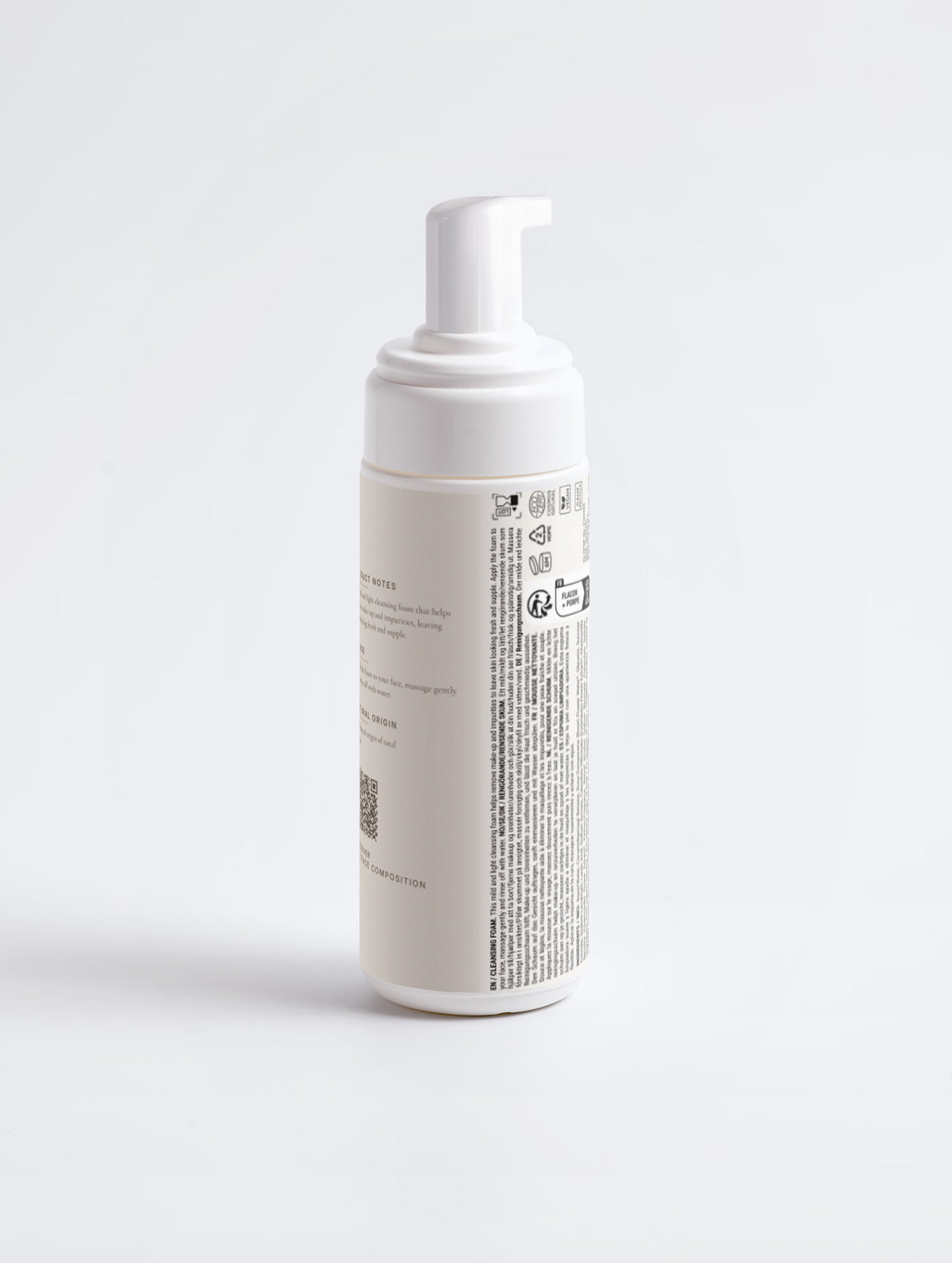 The same bottle rotated to show the product notes, QR code and the printed multilingual regulatory panel.