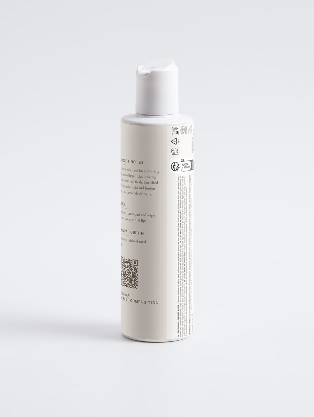 The same bottle rotated to show the product notes, QR code and the printed multilingual regulatory panel.