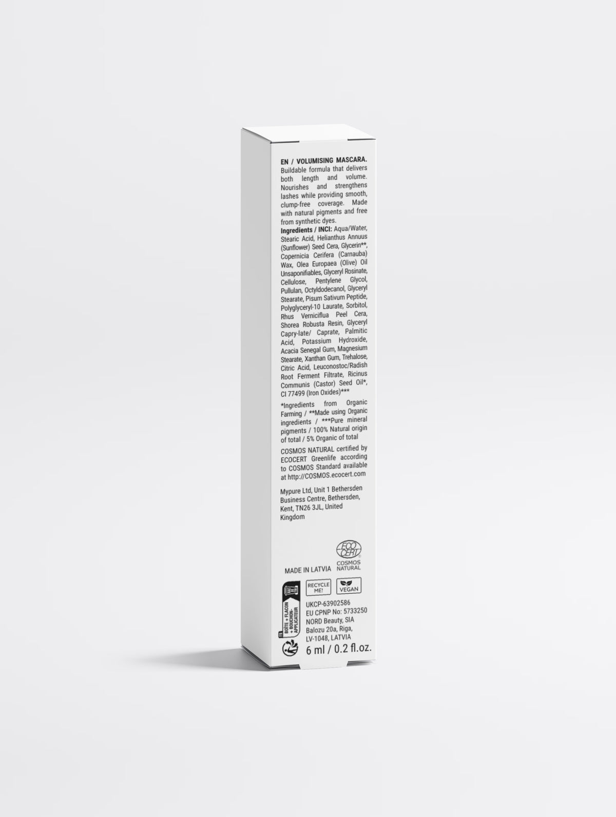 The mascara carton back panel, showing the printed multilingual regulatory text, the full ingredient list, COSMOS NATURAL and vegan marks, the responsible person addresses and MADE IN LATVIA.